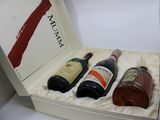 three bottles of wine in a white box on a table