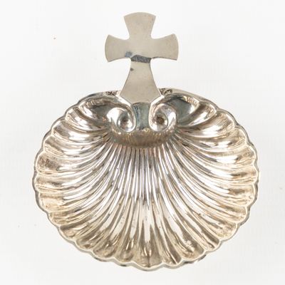 un plateau en argent surmonté d'une croix