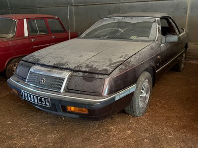 deux vieilles voitures garées dans un garage