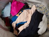a pile of clothes sitting on top of a bed
