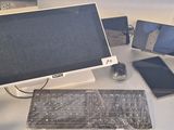 un écran d'ordinateur, un clavier, une souris et d'autres appareils électroniques posés sur un bureau