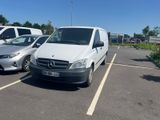 a white van parked in a parking lot next to a silver van