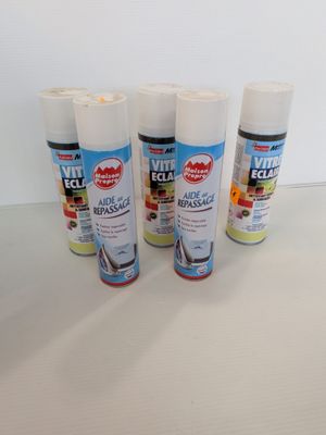 trois bombes de peinture posées sur une table blanche