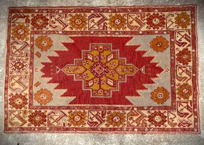 a red and beige rug with a cross design on it