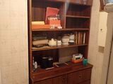 a kitchen with a bookcase and a refrigerator in it