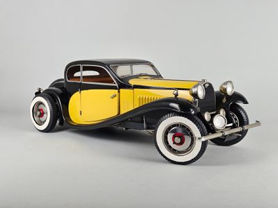 une maquette de voiture jaune et noire posée sur une surface grise