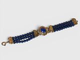 a close up of a blue beaded bracelet with a gold clasp