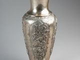 a silver vase that is sitting on a table