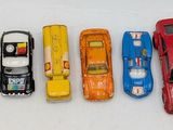several toy cars are lined up in a row on a white surface