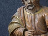 a statue of a man with a beard sitting on a stool