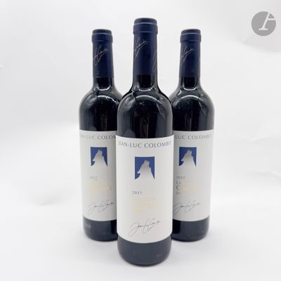 trois bouteilles de vin rouge posées sur une table blanche