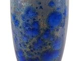un vase bleu posé sur une surface blanche