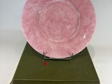 a pink plate sitting on top of a stack of books