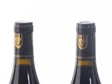 three bottles of wine are lined up on a white surface