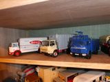 de nombreux camions miniatures posés sur une étagère dans une pièce