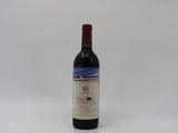 the bottle of wine is sitting on a white surface