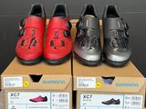 quatre paires de chaussures dans une boîte posée par terre