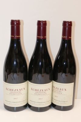 trois bouteilles de vin rouge sont alignées sur une table