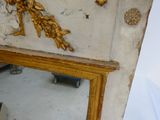a mirror with a gold frame and a gold bird on it