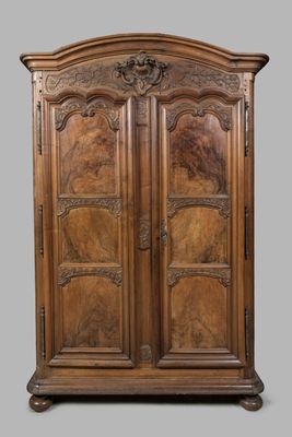 une vieille armoire en bois avec des gravures et des sculptures sur les portes