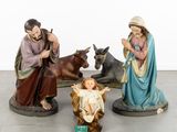 three figurines of jesus and a baby jesus in a manger