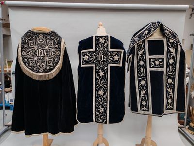 trois robes noires et blanches exposées dans un magasin