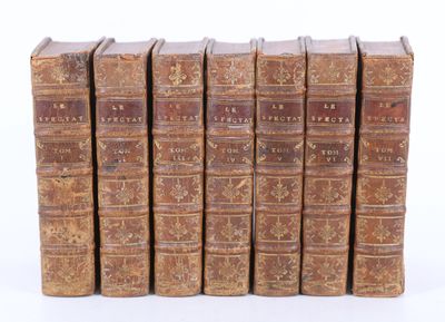 six vieux livres alignés sur une surface blanche