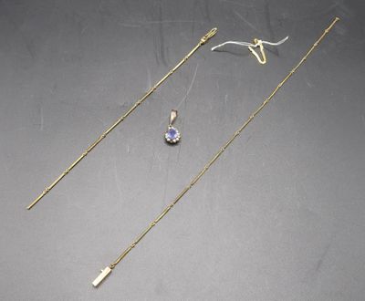 two gold necklaces and a pair of earrings on a table