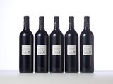 four bottles of wine are lined up on a table