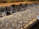 many empty wine glasses lined up on a table