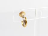a close up of a pair of gold hoop earrings on a clear surface