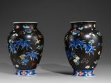 pair of black vases with blue and red flowers on them