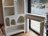 a white bookcase in the corner of a room next to a window