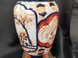 un vase posé sur un socle, sur fond noir