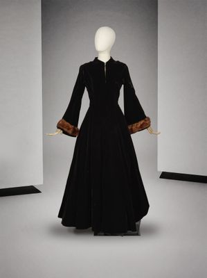une photo d'un mannequin portant une robe noire à poignets en fourrure