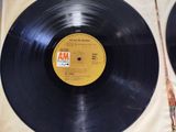 two black vinyl records on a table with a white cloth