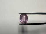 a close up of a person holding a pair of pliers with a pink diamond