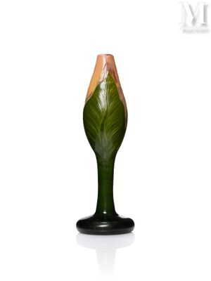 un vase vert orné d'une fleur, posé sur une surface blanche