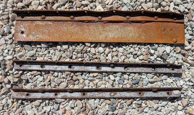 a rusted piece of metal sitting on a pile of rocks