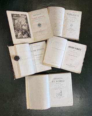 plusieurs livres ouverts posés sur une table, avec un bouton par-dessus