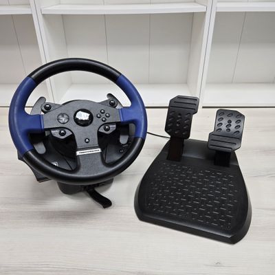 a steering wheel and pedals sitting on a table