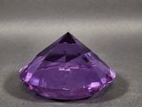 a purple amethorate stone on a gray surface