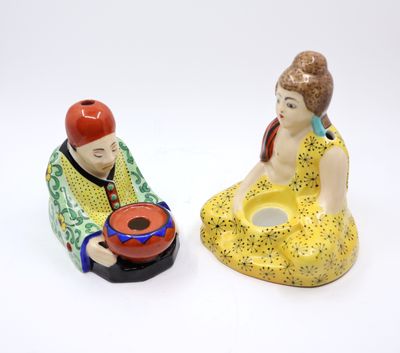 two figurines of a man and a woman sitting next to each other