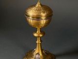 an ornate gold cup with a cross on top of it