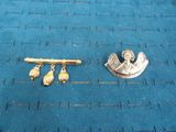 a gold brooch and a gold pin on a blue surface