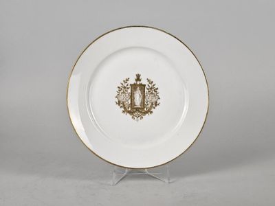 a white and gold plate with a crest on it