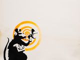graffiti art of a rat with a clock and a bird on it ' s back