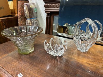 three glass vases sitting on a table with a mirror in the background