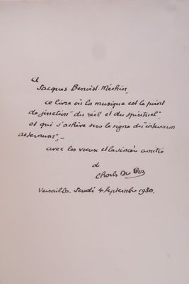 un livre ouvert, sur lequel est inscrit un poème écrit à la main, posé sur une table