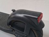 a black scooter with a red light on top of it